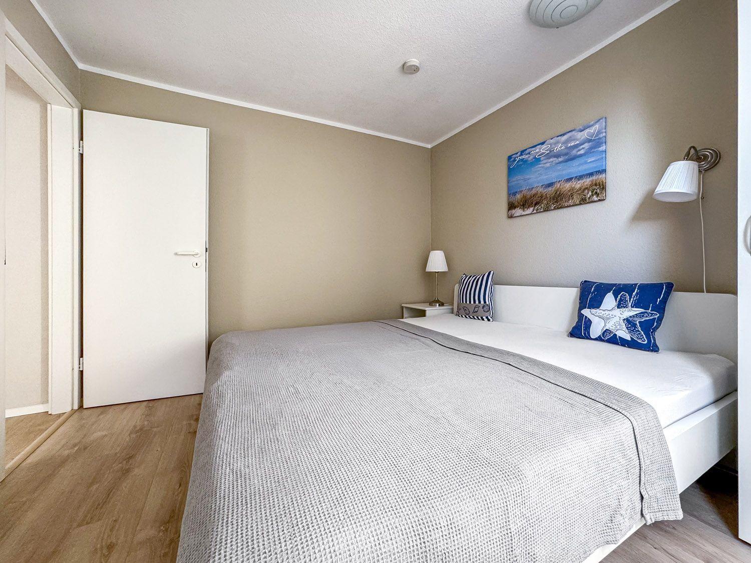 Schlafzimmer mit Bett, Wandbild und Nachttisch