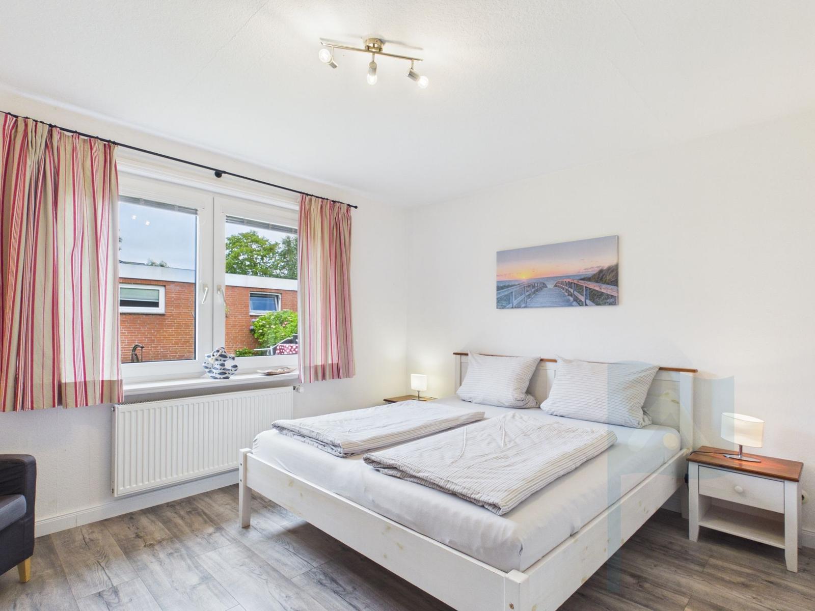 Schlafzimmer mit Doppelbett, Fenster und Nachttisch