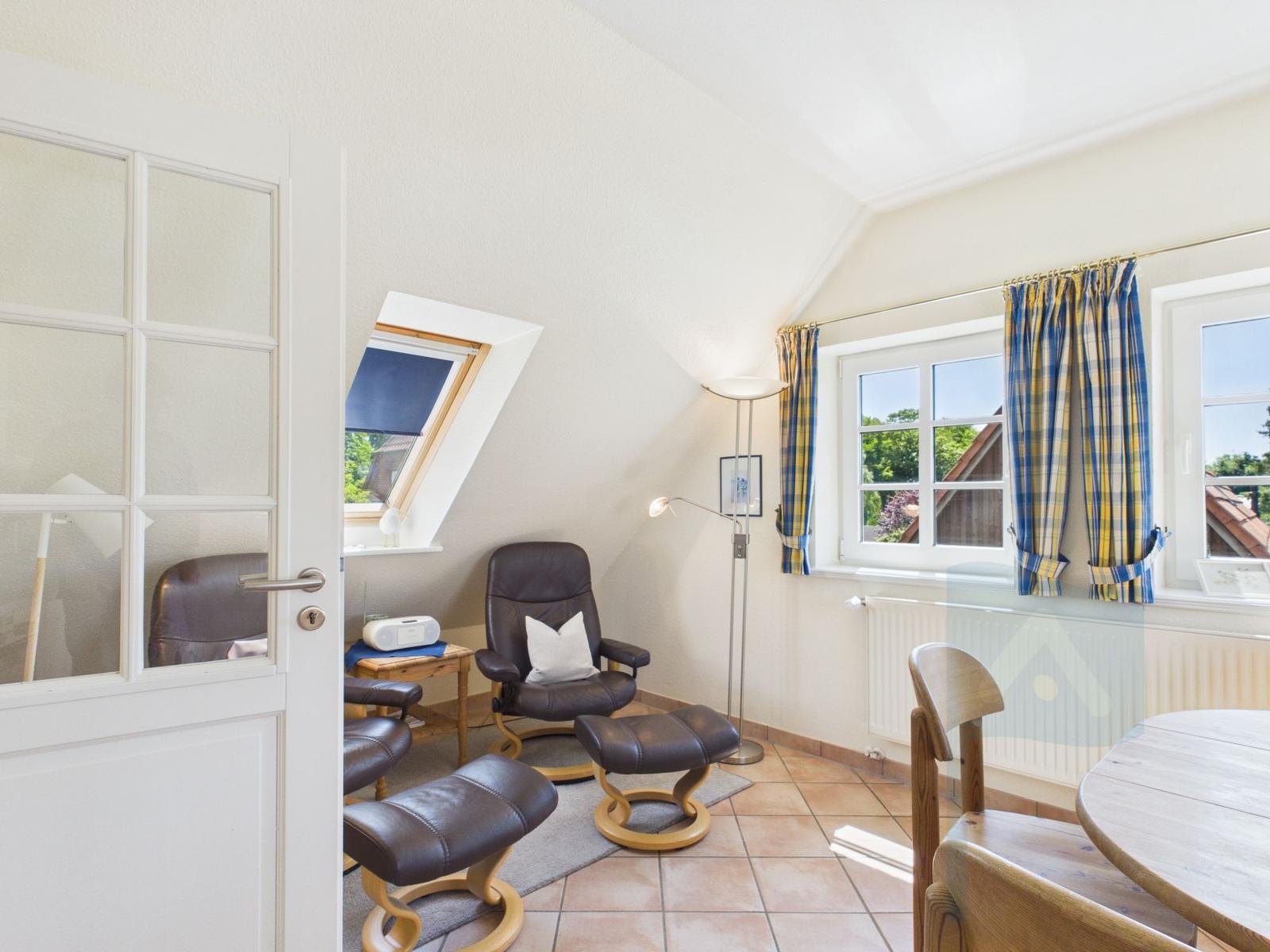 Dachgeschosszimmer mit Sitzgelegenheit, Fenster und Tür