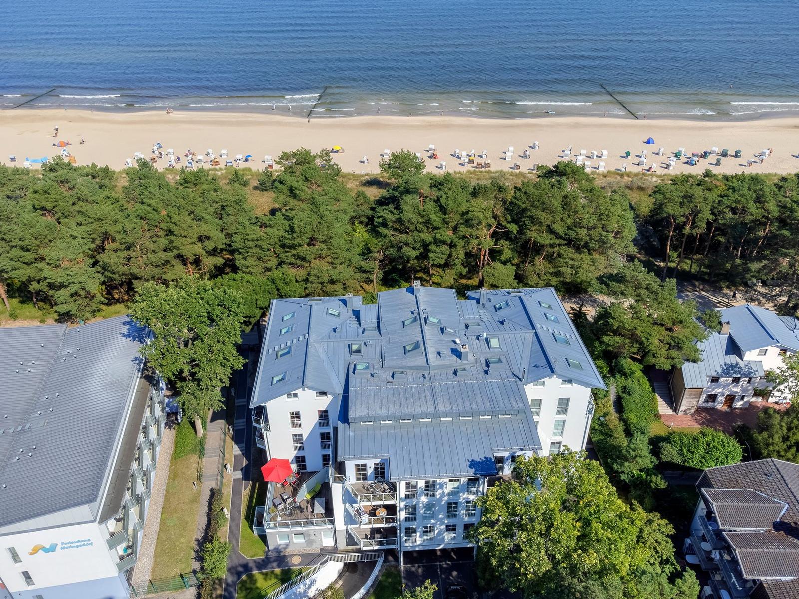 House with balcony, beach and forest in background