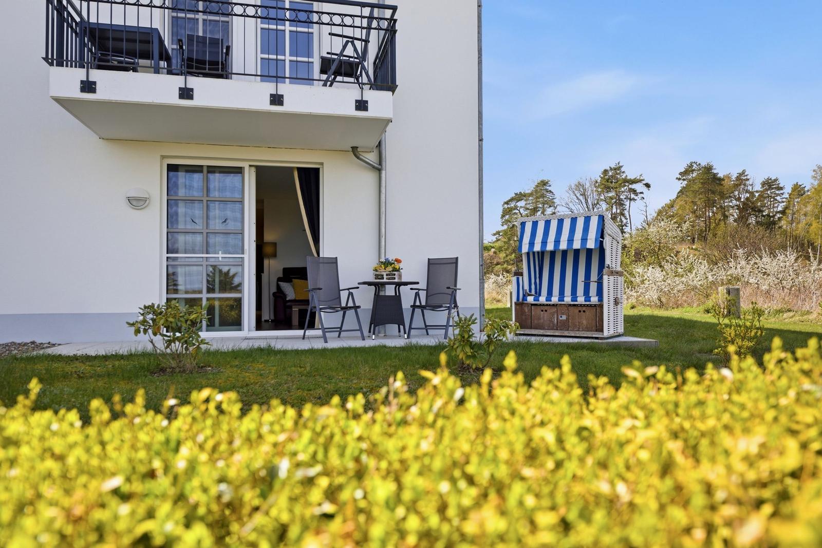 Wohnung mit Balkon, Terrasse und Strandkorb im Garten.