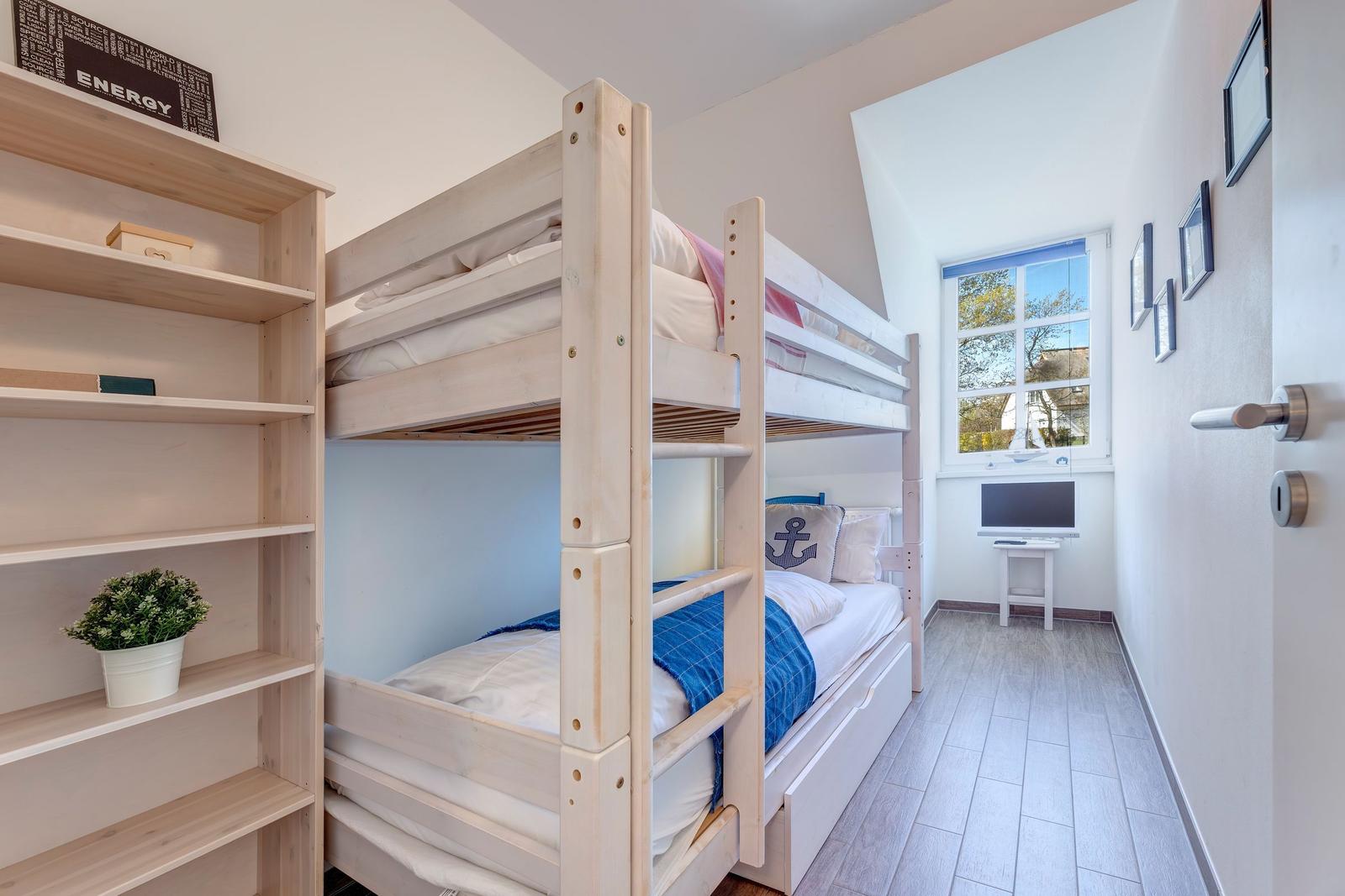Zimmer mit Doppelstockbett, Regal und Fenster mit Blick nach draußen.