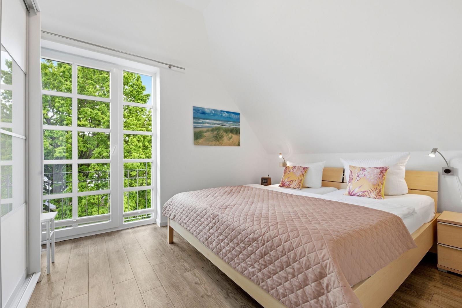Bedroom with bed, window, and wall art.