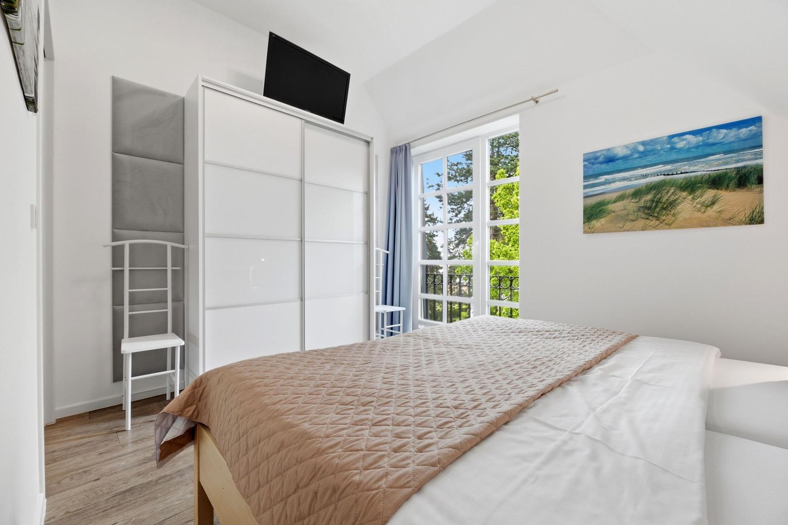 Bedroom with bed, wardrobe, and window to the garden.