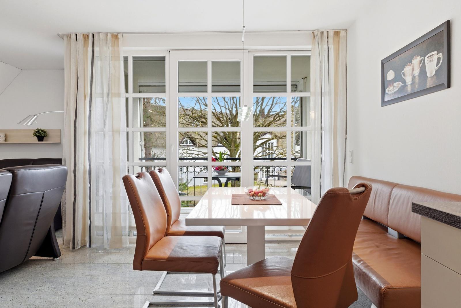 Dining area with brown leather seats and view of balcony