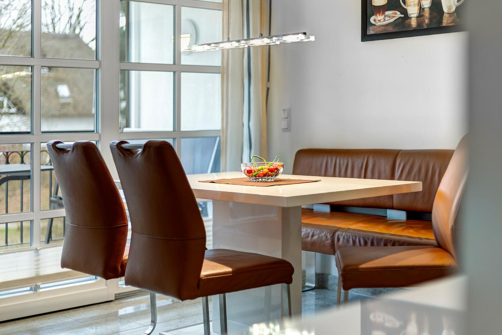 Dining table with brown leather seats and window view