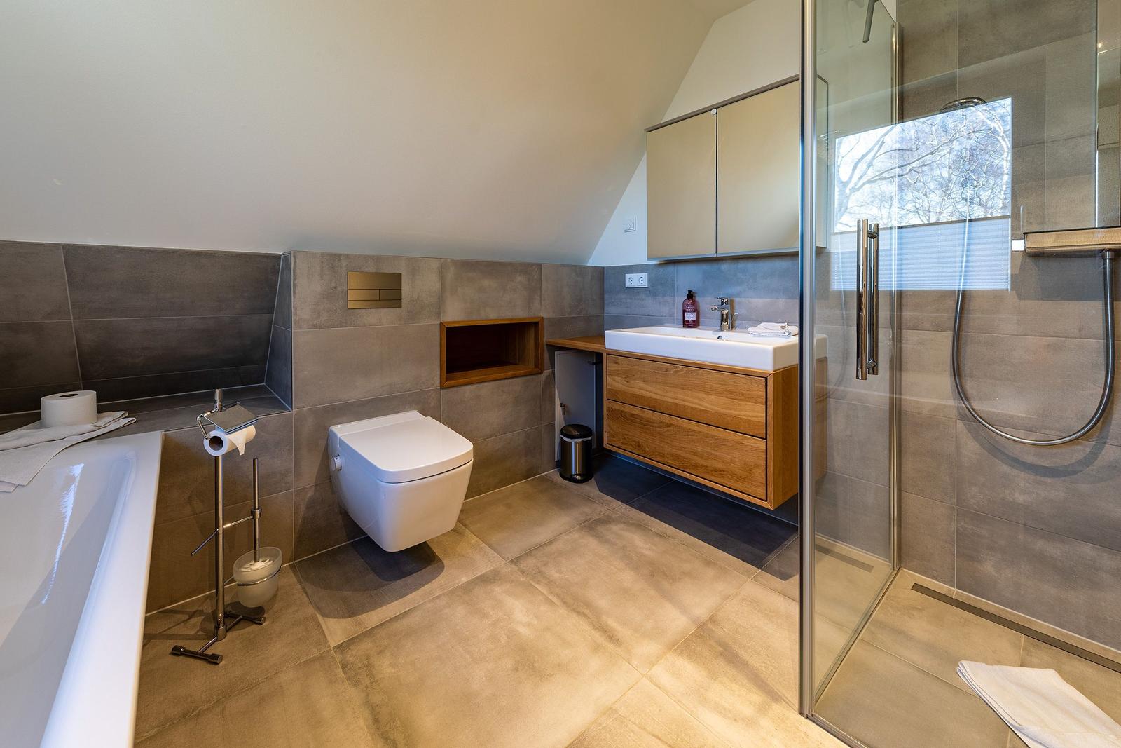 Badezimmer mit Dusche, Badewanne, Waschbecken und Toilette.