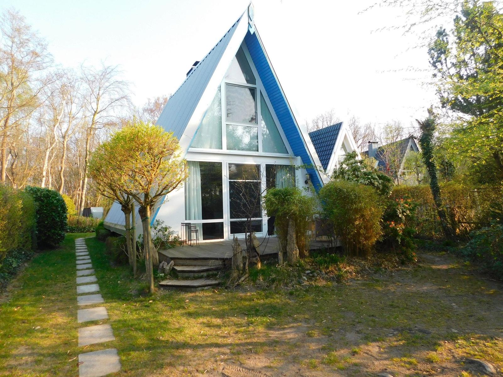 A-frame-Haus mit großem Fenster und Terrasse im Garten