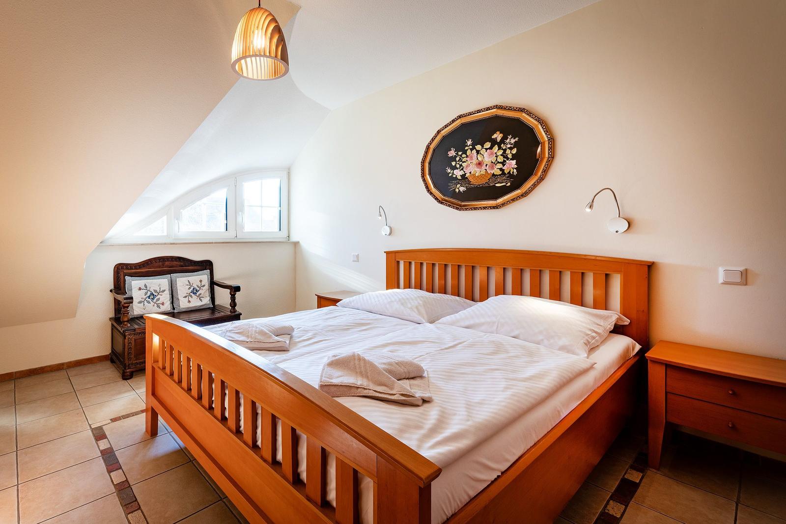 Schlafzimmer mit Holzbett, Fenster und Wandbild