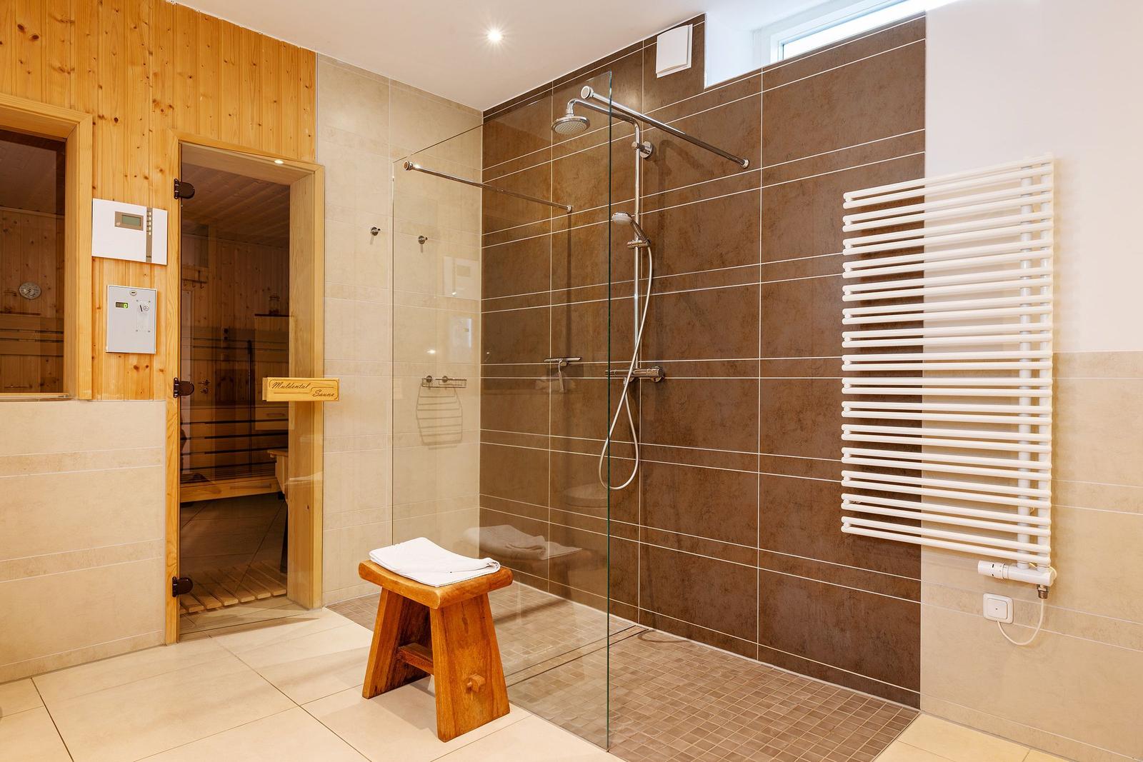 Dusche mit Glaswand, Sauna und Heizkörper an der Wand