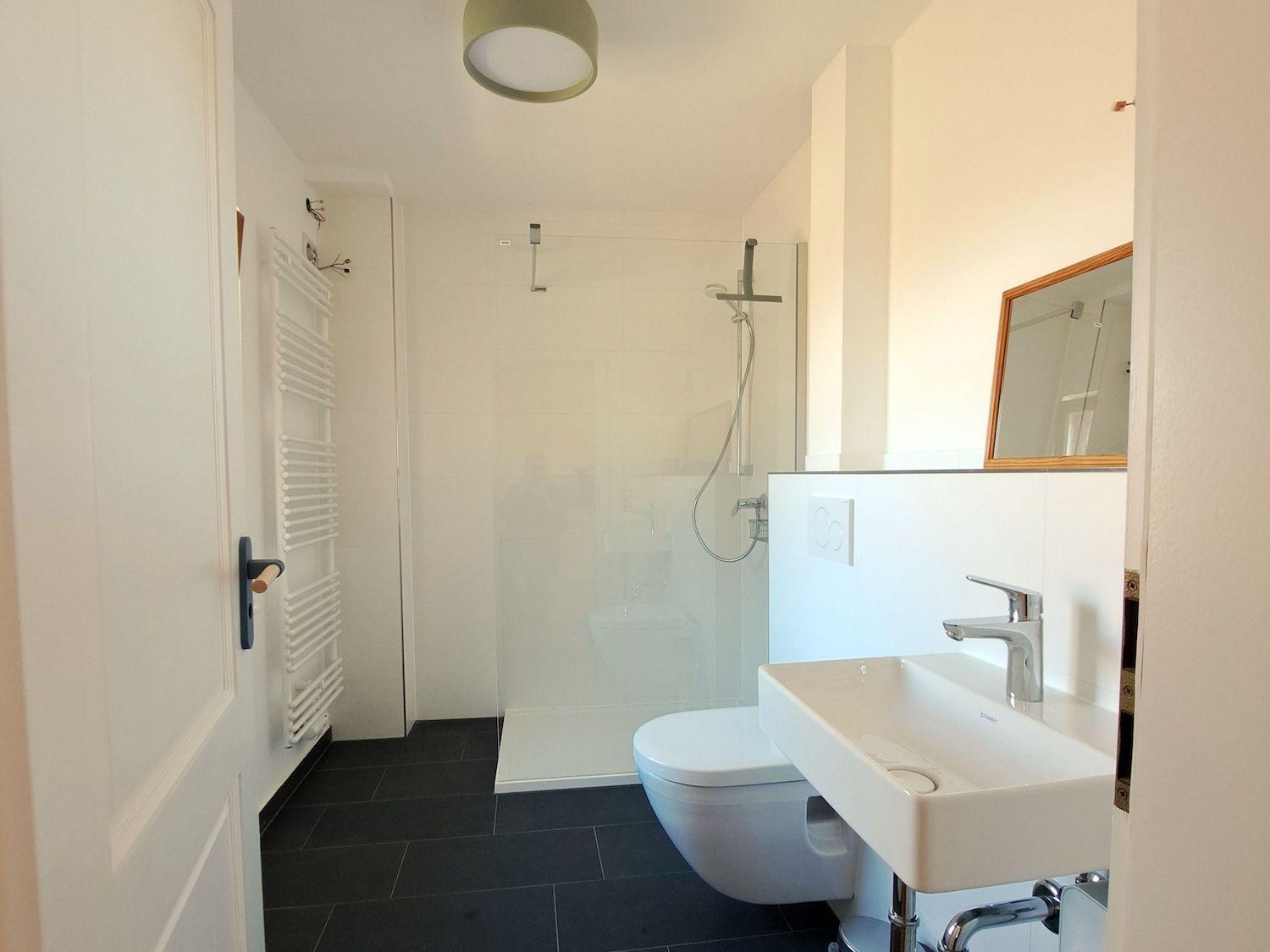 Badezimmer mit Dusche, Toilette und Waschbecken