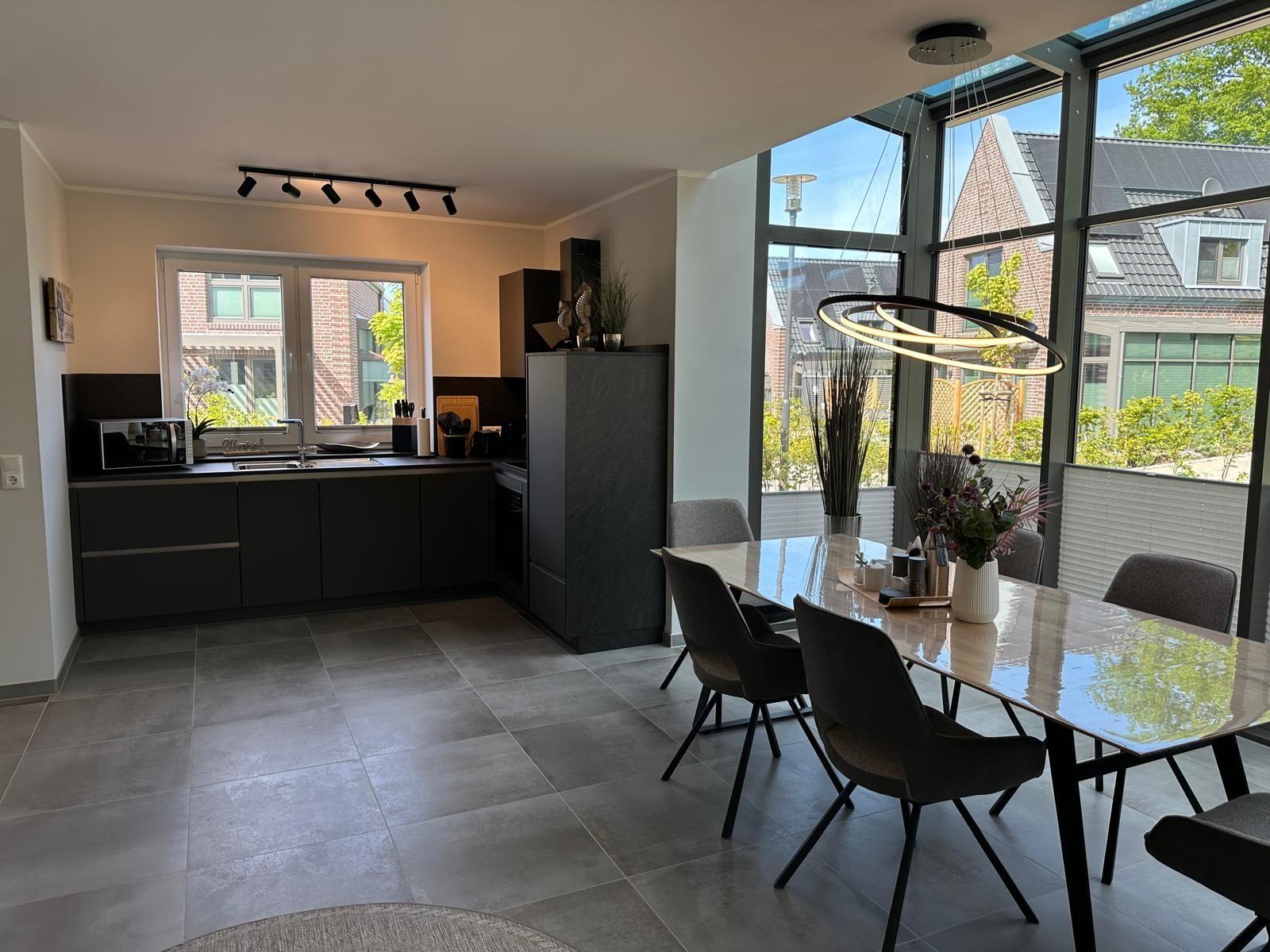 Moderne Küche mit Essbereich und großem Fensterblick auf die Straße.