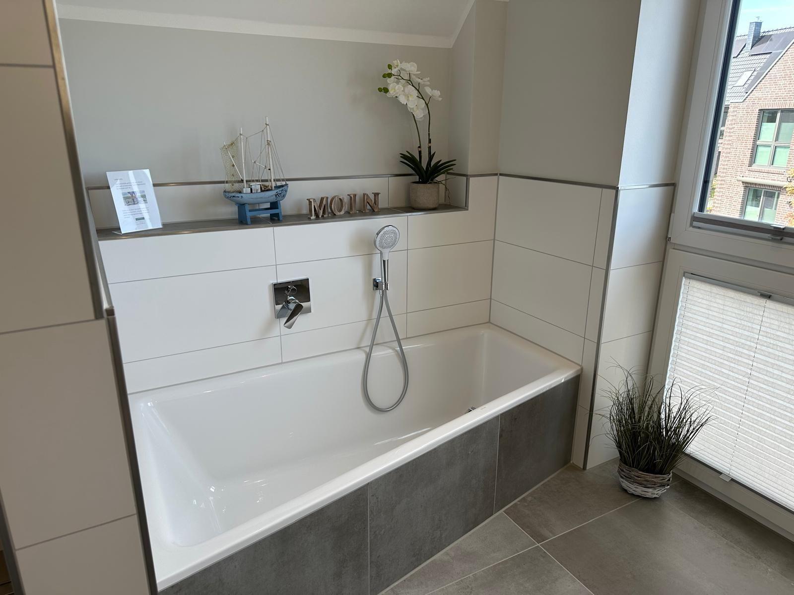 Bad mit Badewanne, Duschkopf und Fenster mit Blick.