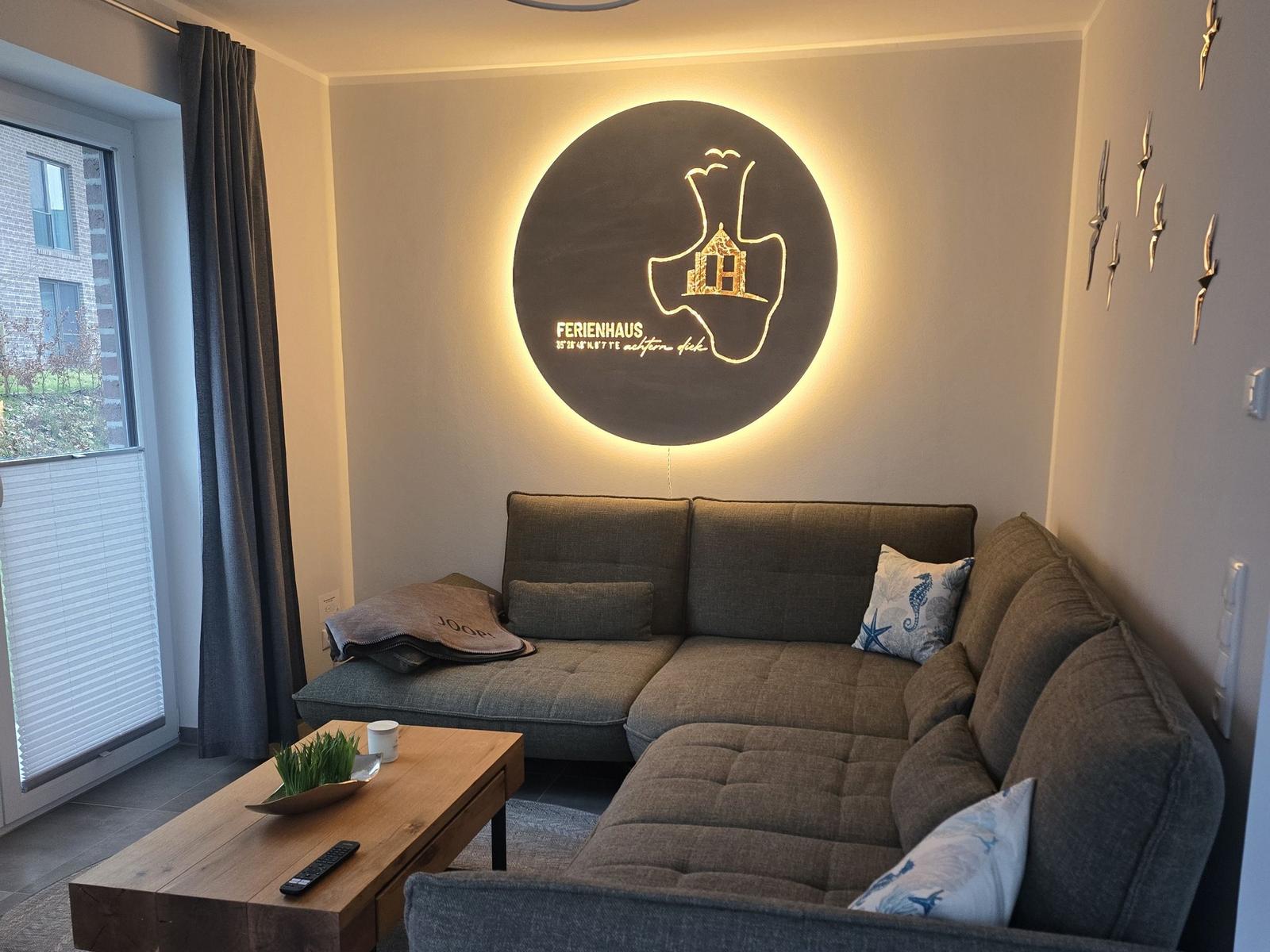 Wohnzimmer mit Sofa, Tisch und Wanddekoration.