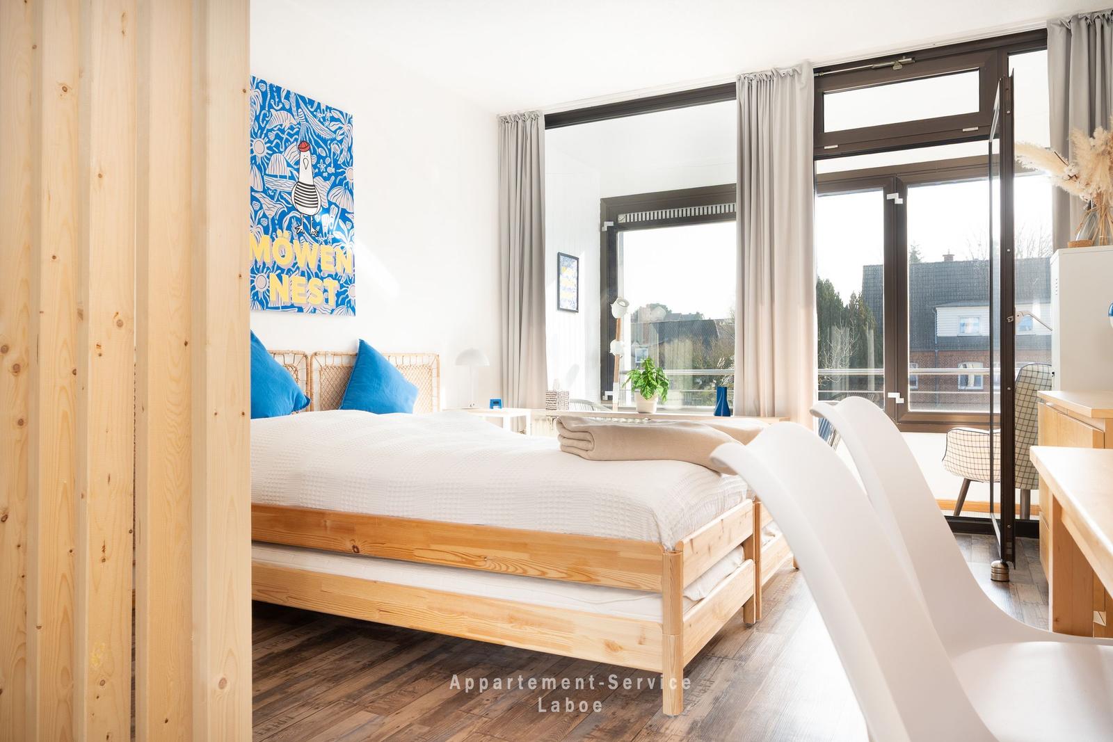 Schlafzimmer mit Holzbett, Fenster und Wandbild.