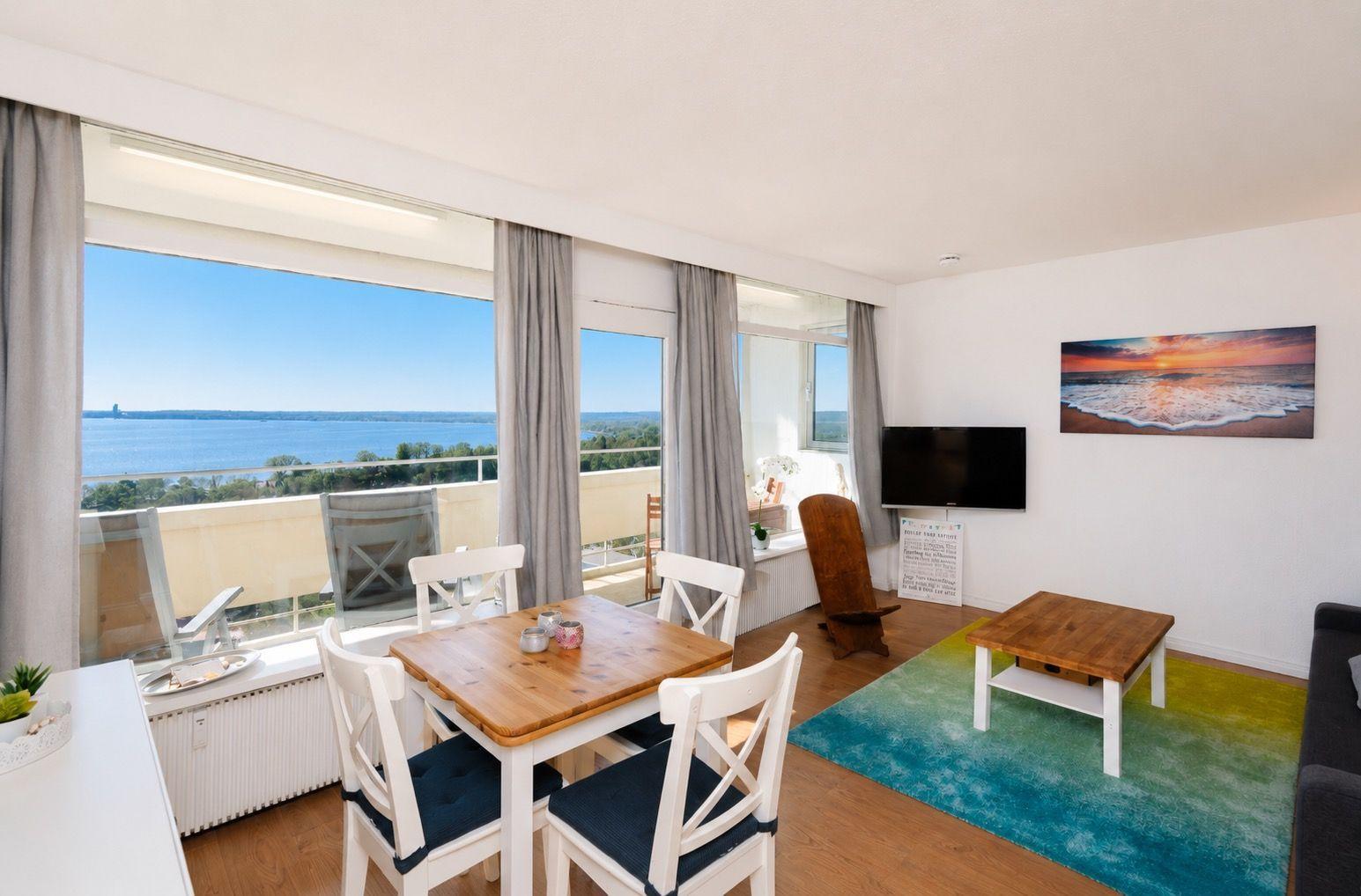 Apartment with dining area and balcony view of water