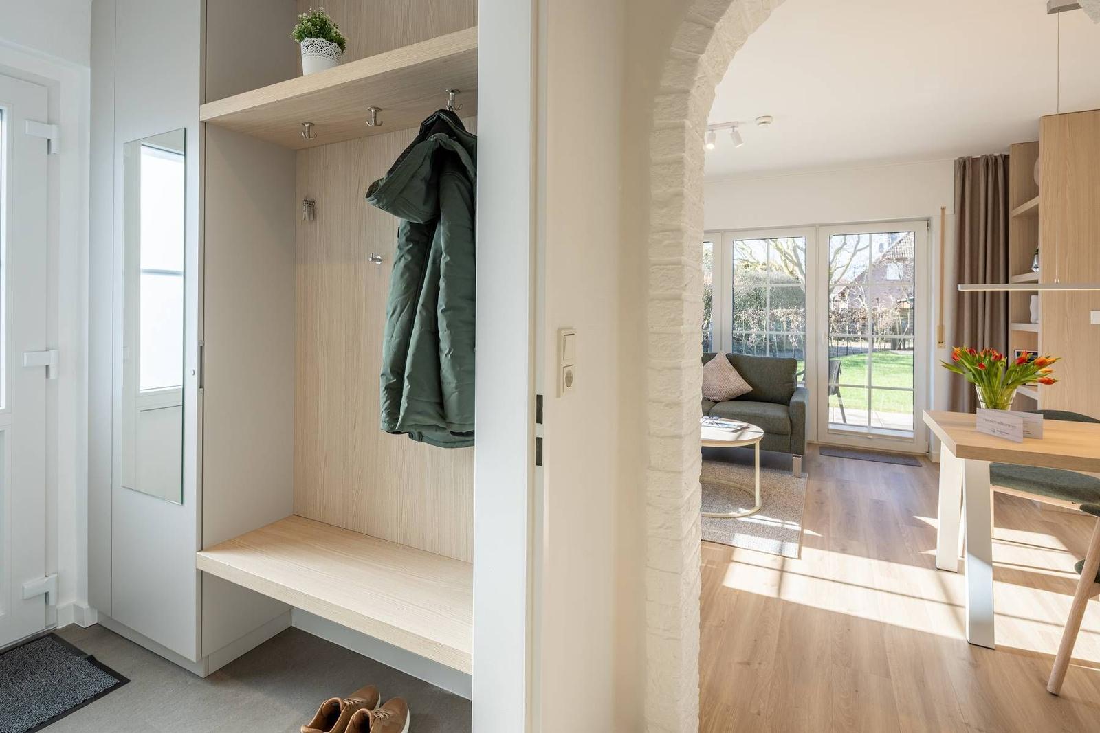 Eingangsbereich mit Garderobe und Blick in Wohn- und Essbereich.