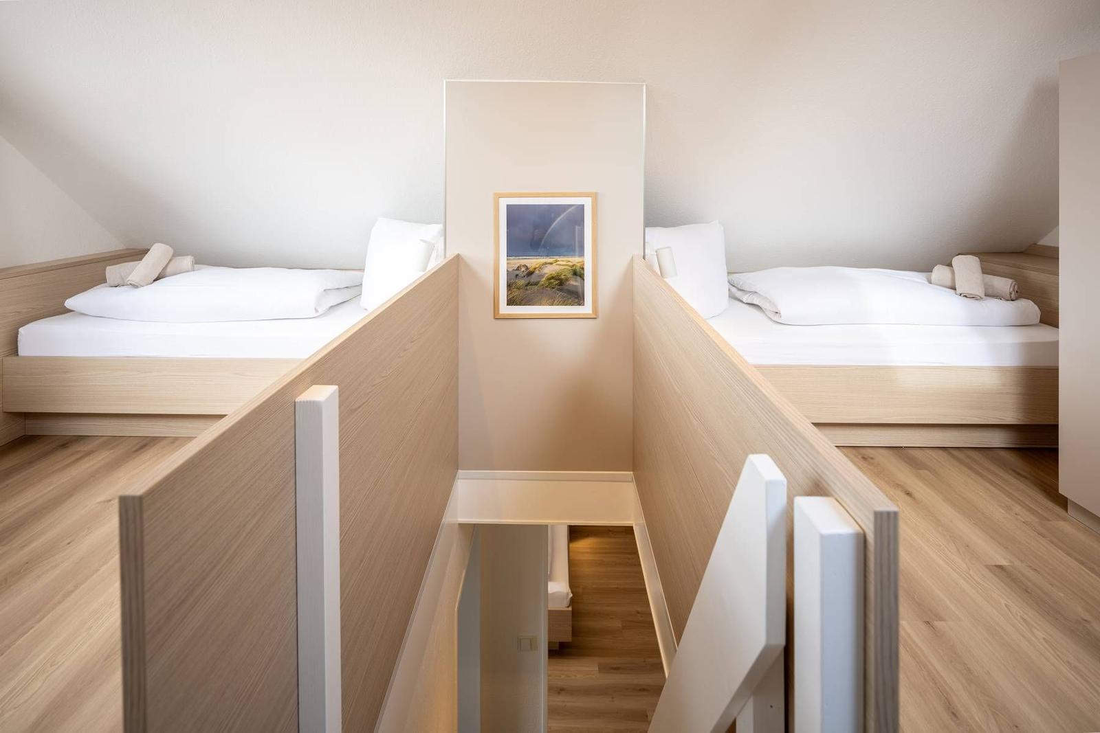 Zwei Schlafplätze mit Holzbetten und einem Bild an der Wand.