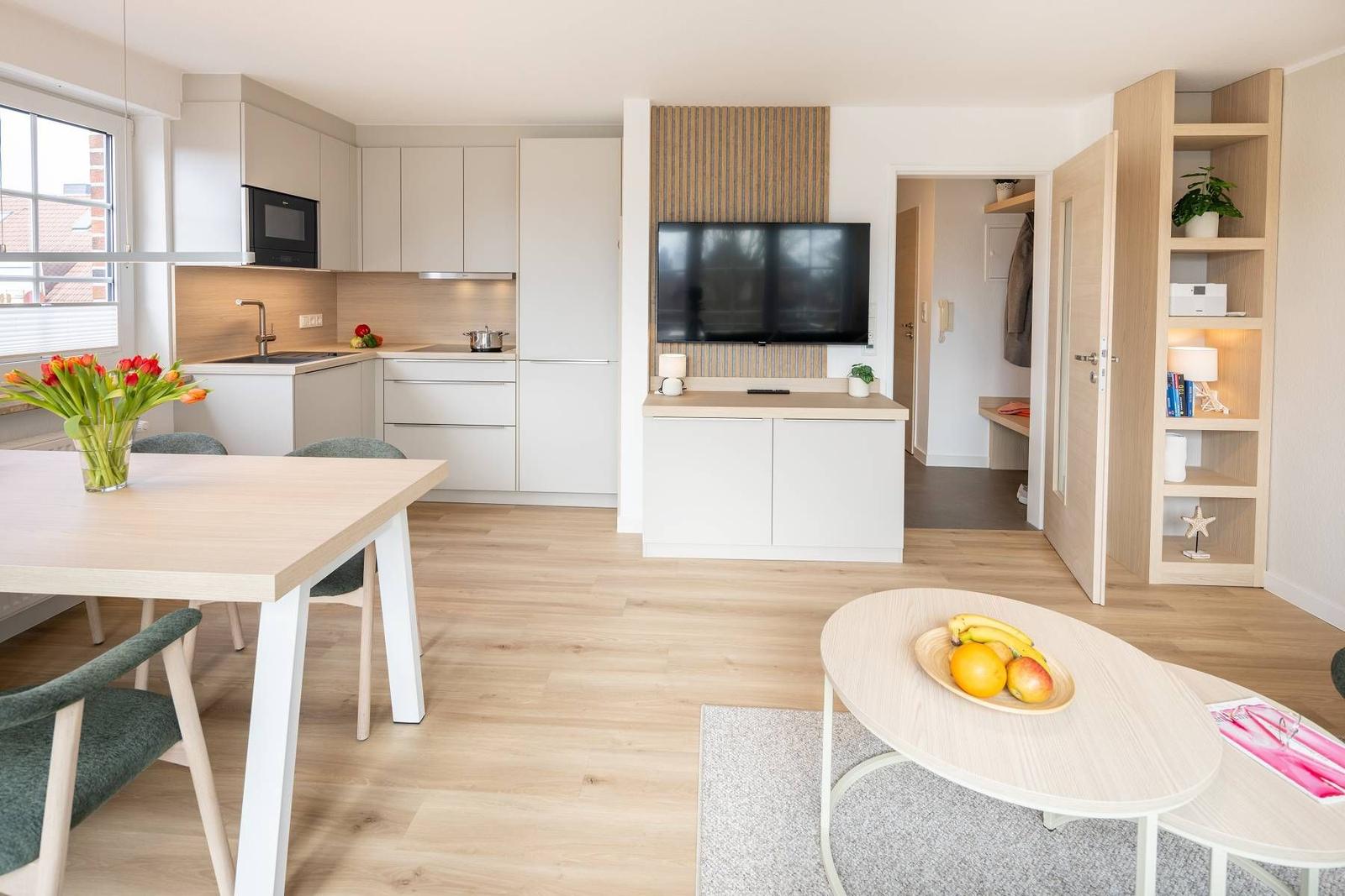 Moderne Küche mit Essbereich und Wohnbereich mit Fernseher.