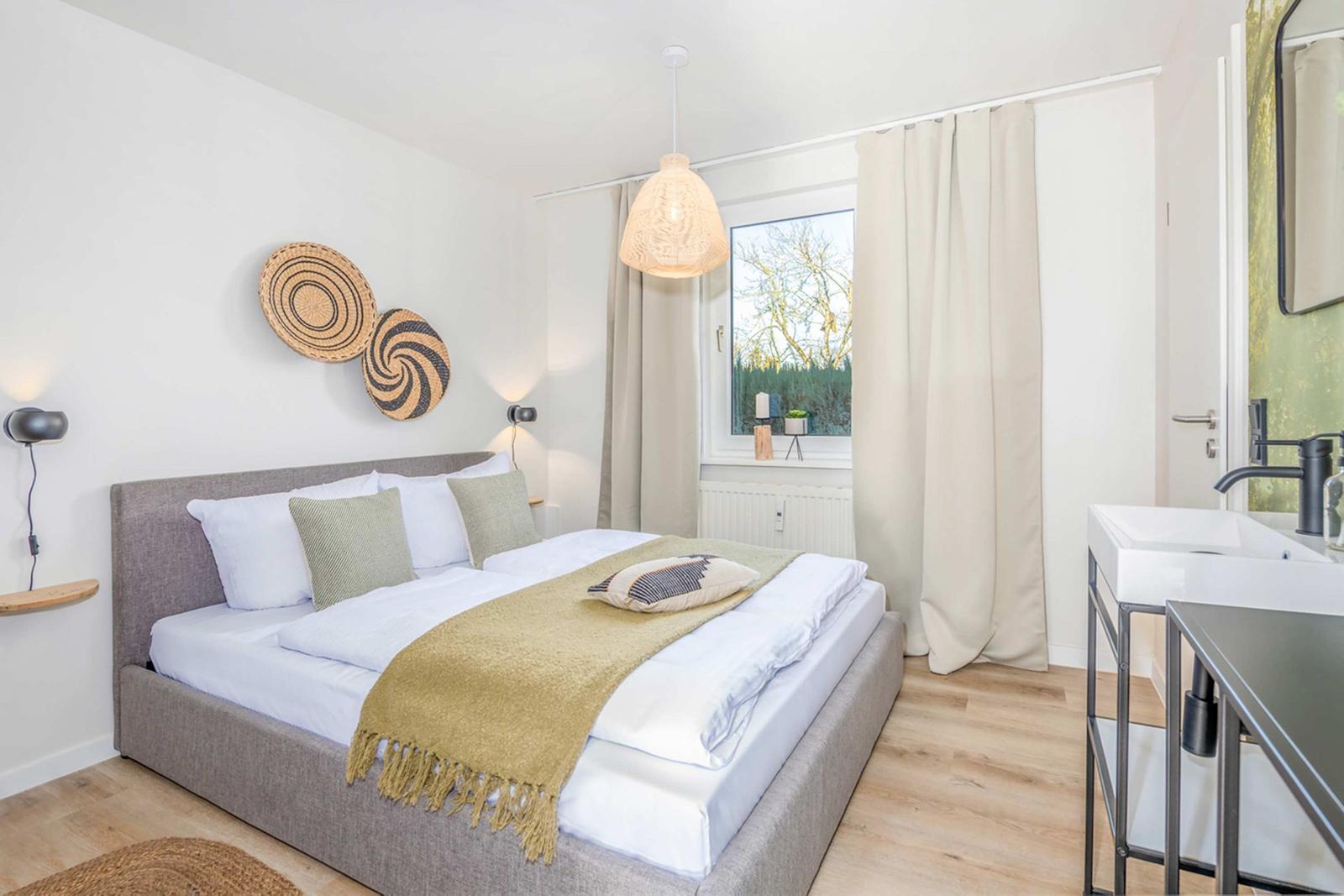 Bedroom with double bed, window, and bathroom area