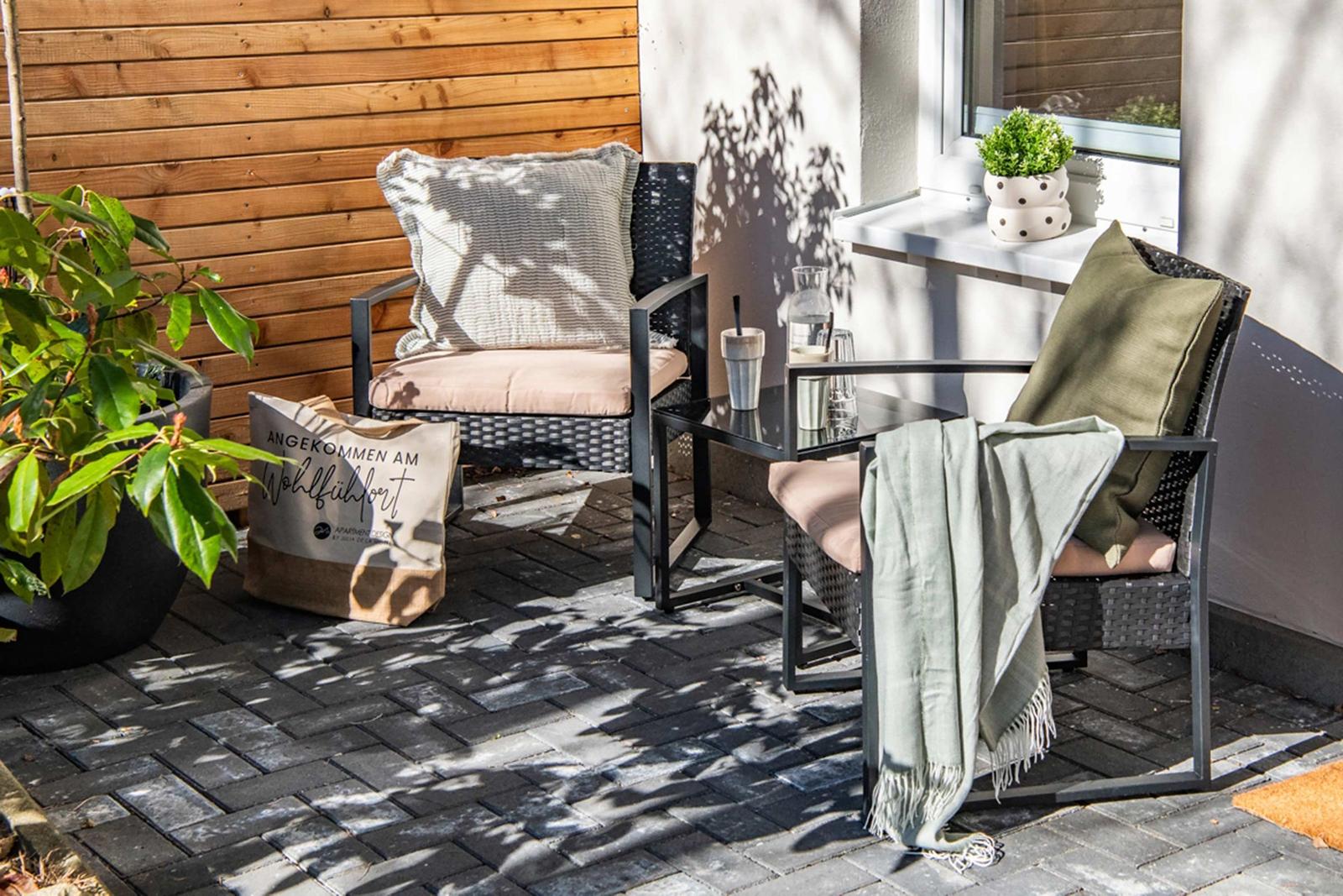 Terrace with two seating areas, plants, and a windowsill.
