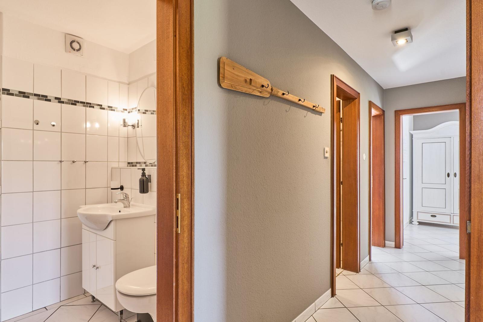 Flur mit Holzstange, Badezimmer und Schlafzimmer