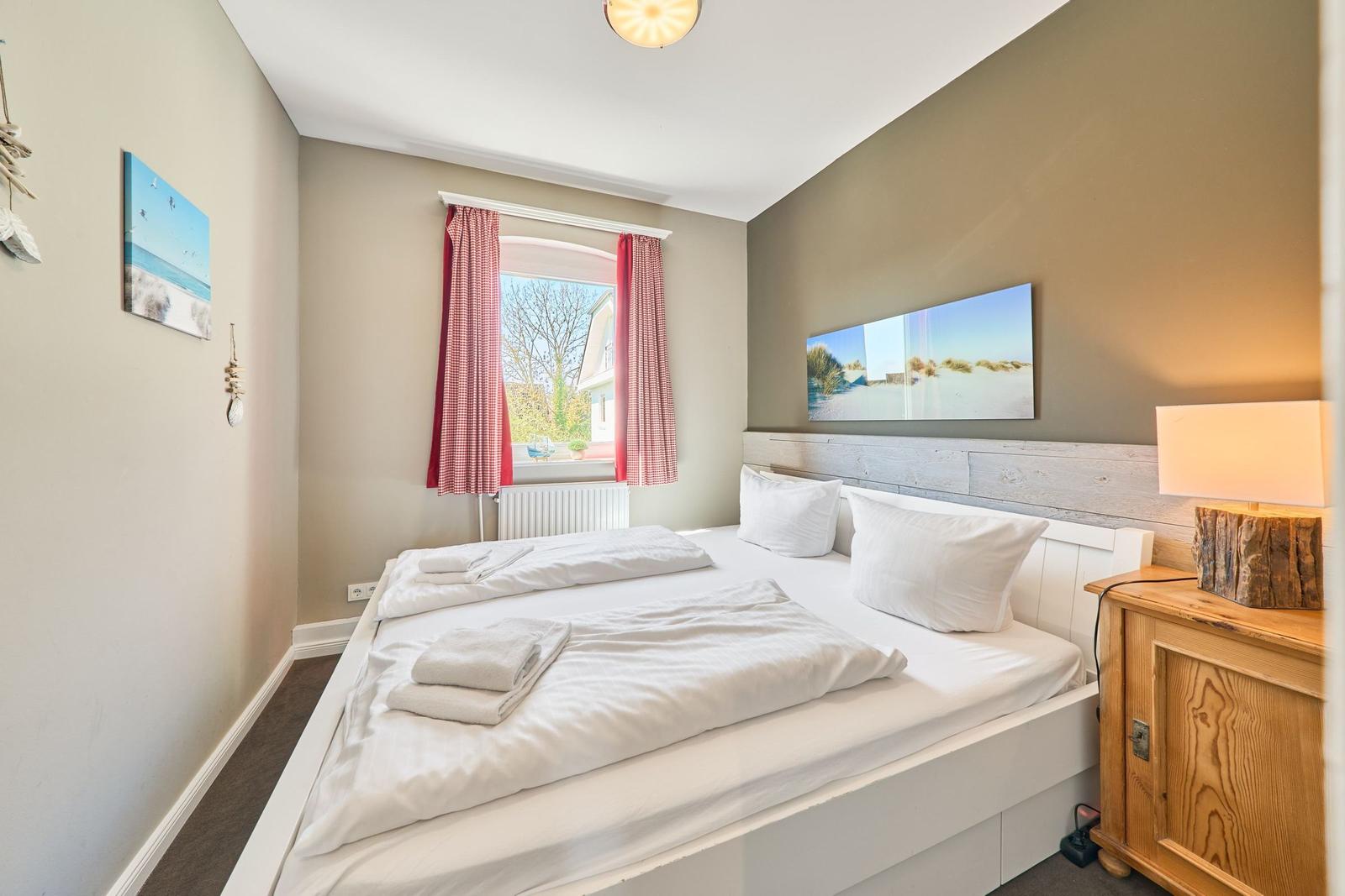 Schlafzimmer mit Bett, Fenster und Nachttisch