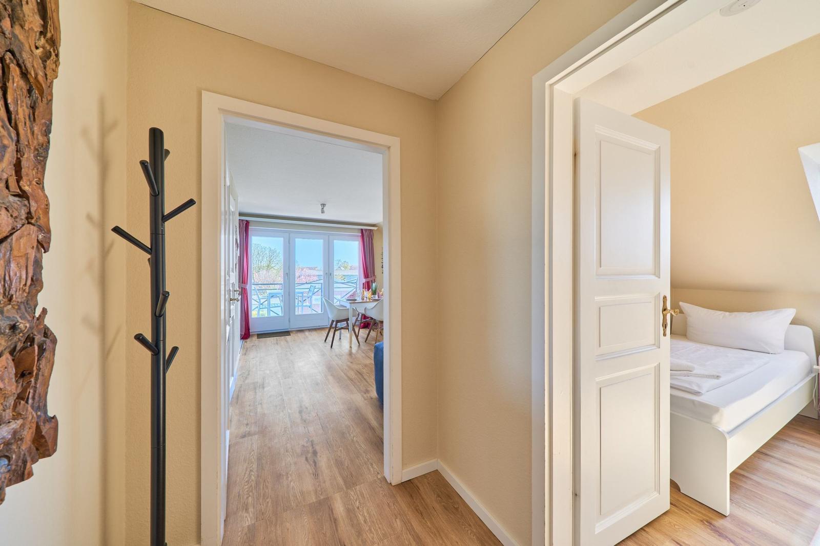 Hallenflur mit Schlafzimmer und Essbereich mit Balkon.