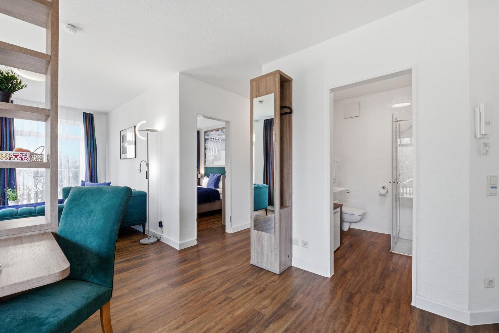 Wohnung mit Wohnbereich, Schlafzimmer und Bad. Holzdielenboden und Teppichboden.