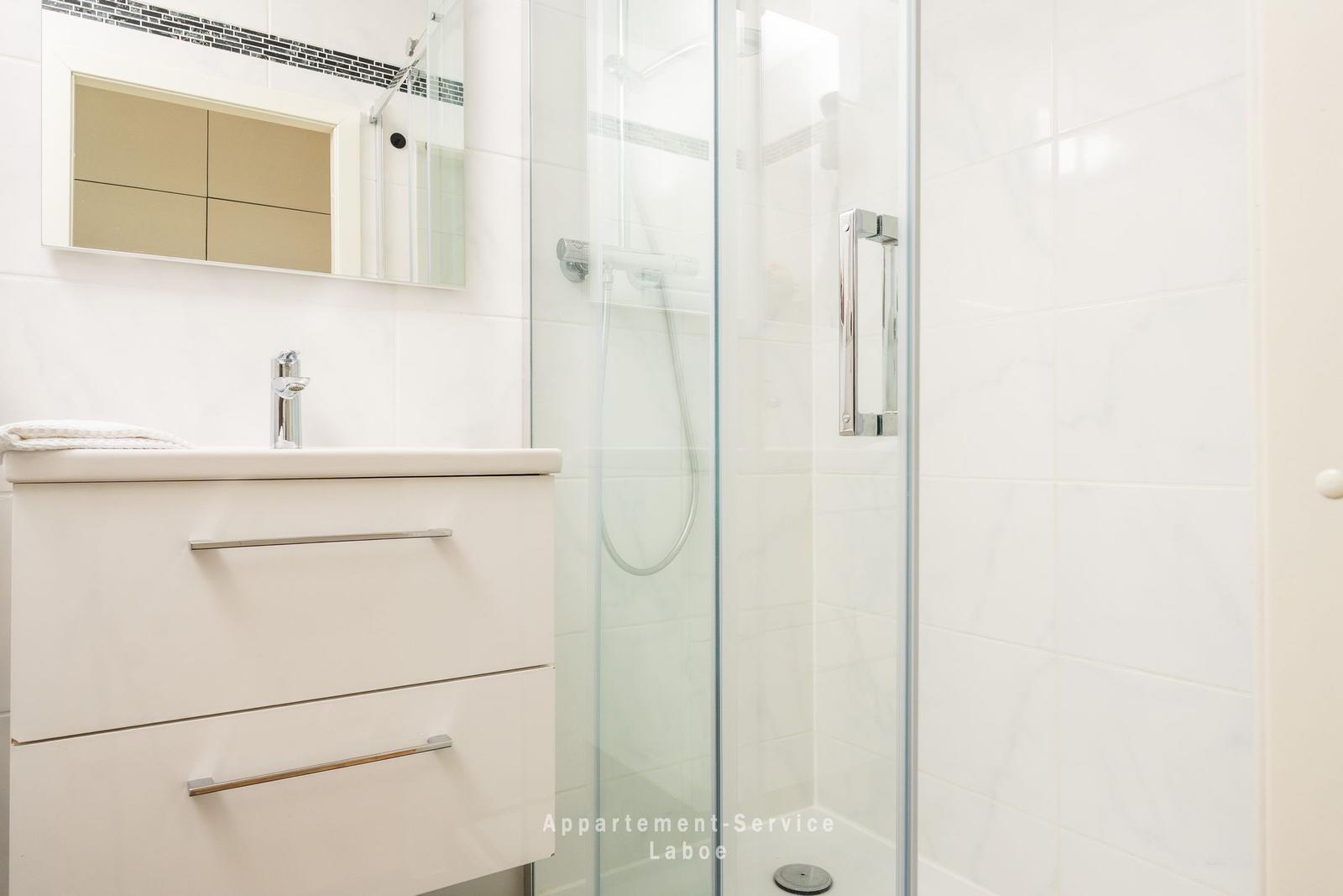 Bad mit Dusche und Waschbecken mit Spiegel