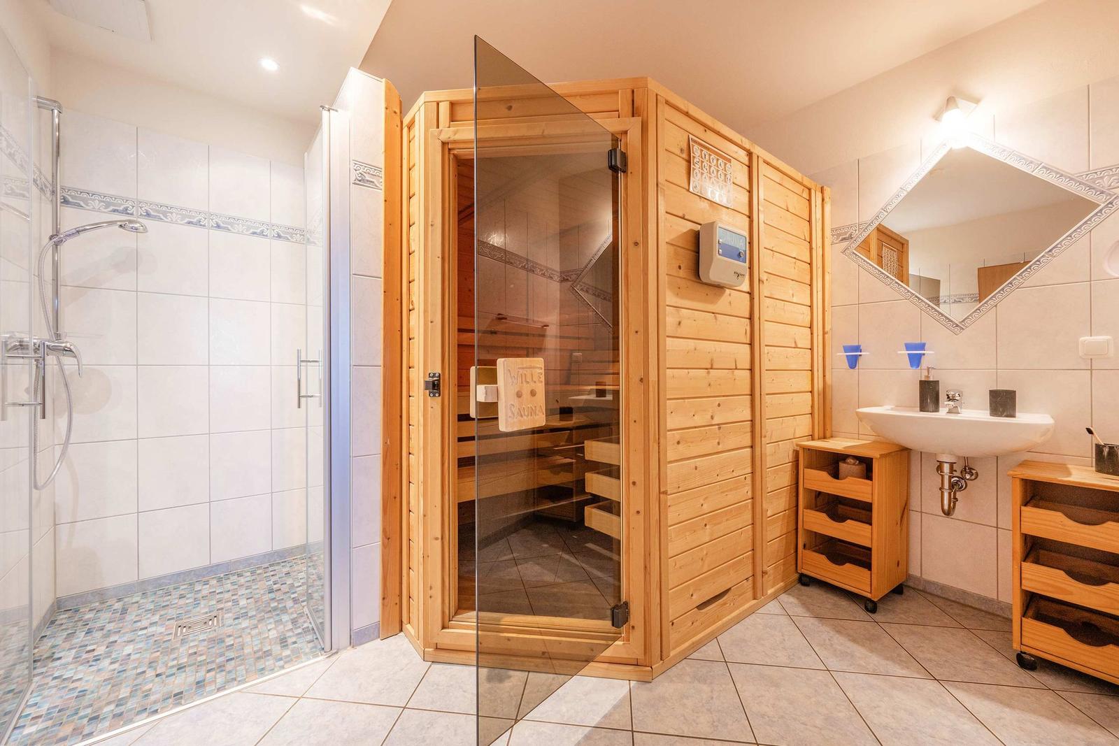 Dusche, Sauna und Waschbecken im Badezimmer.