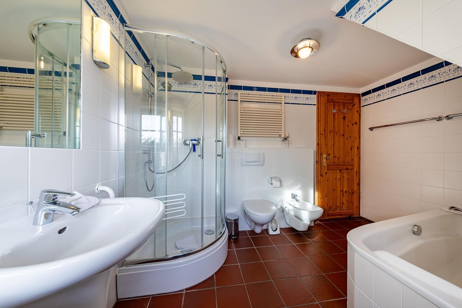 Badezimmer mit Dusche, Badewanne, Toilette und Waschbecken