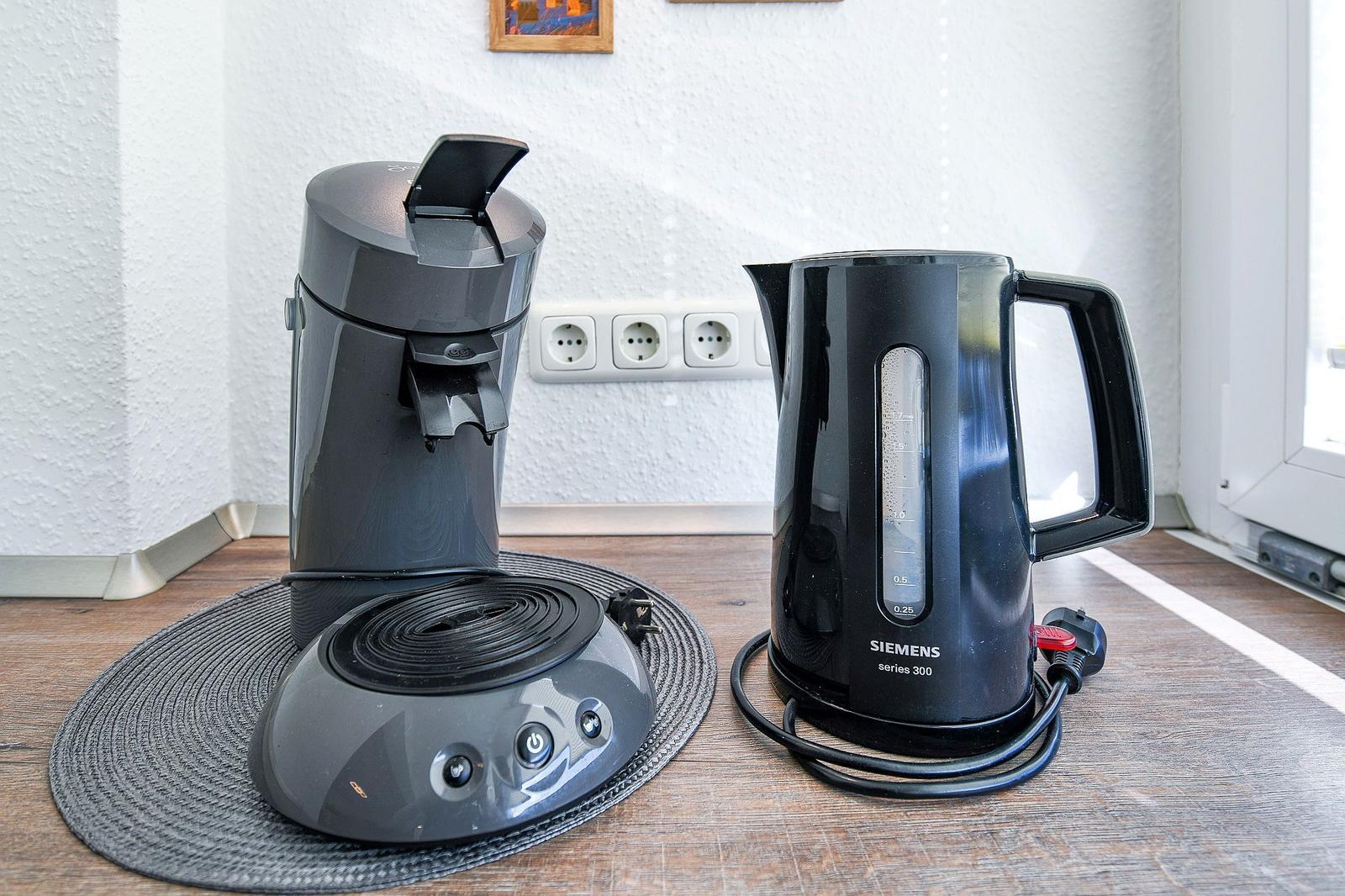 Kaffeemaschine und Wasserkocher auf Küchenarbeitsfläche.
