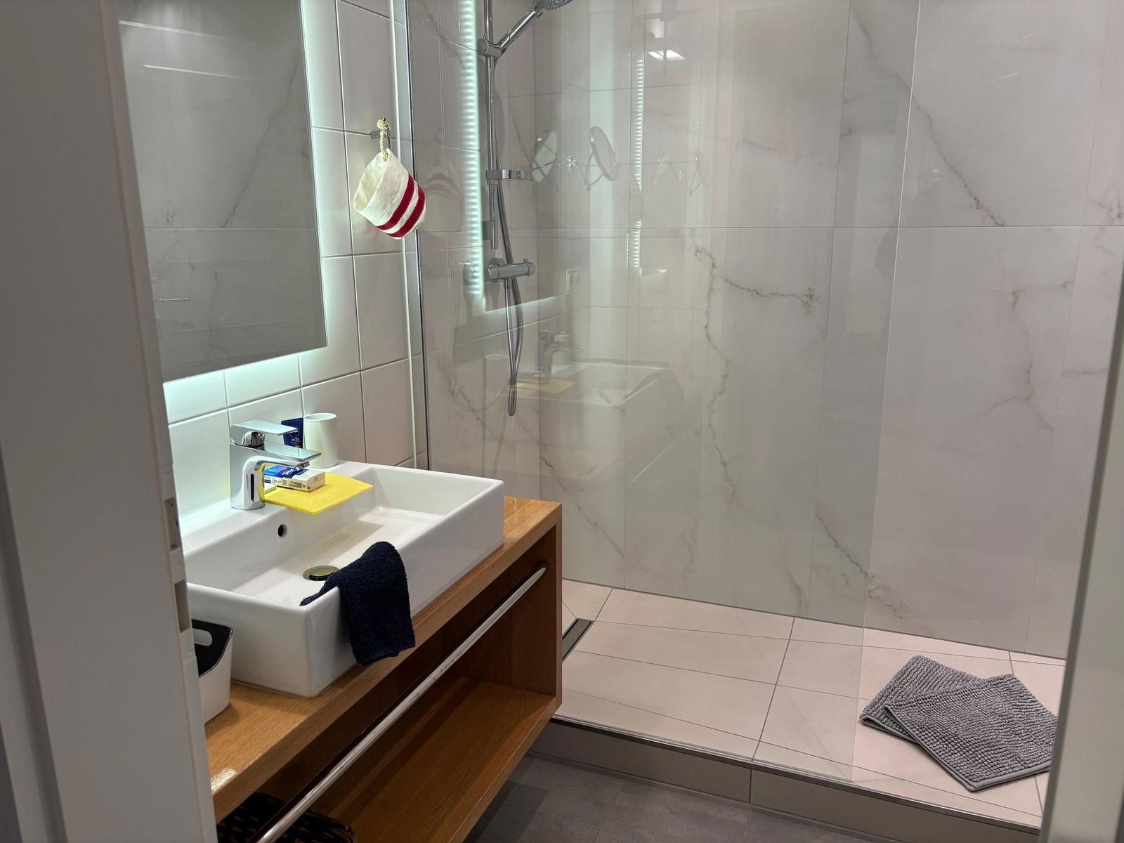 Bathroom with shower, sink, and mirror