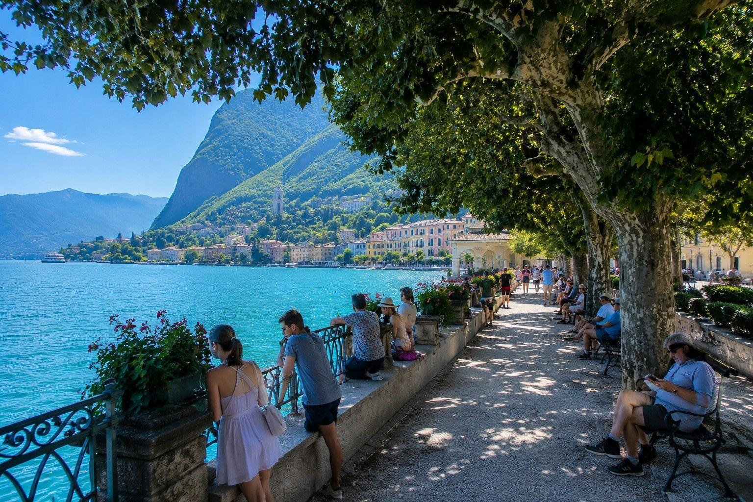 Lange Promenade entlang des Sees mit Bäumen und Blick auf die gegenüberliegende Uferseite.