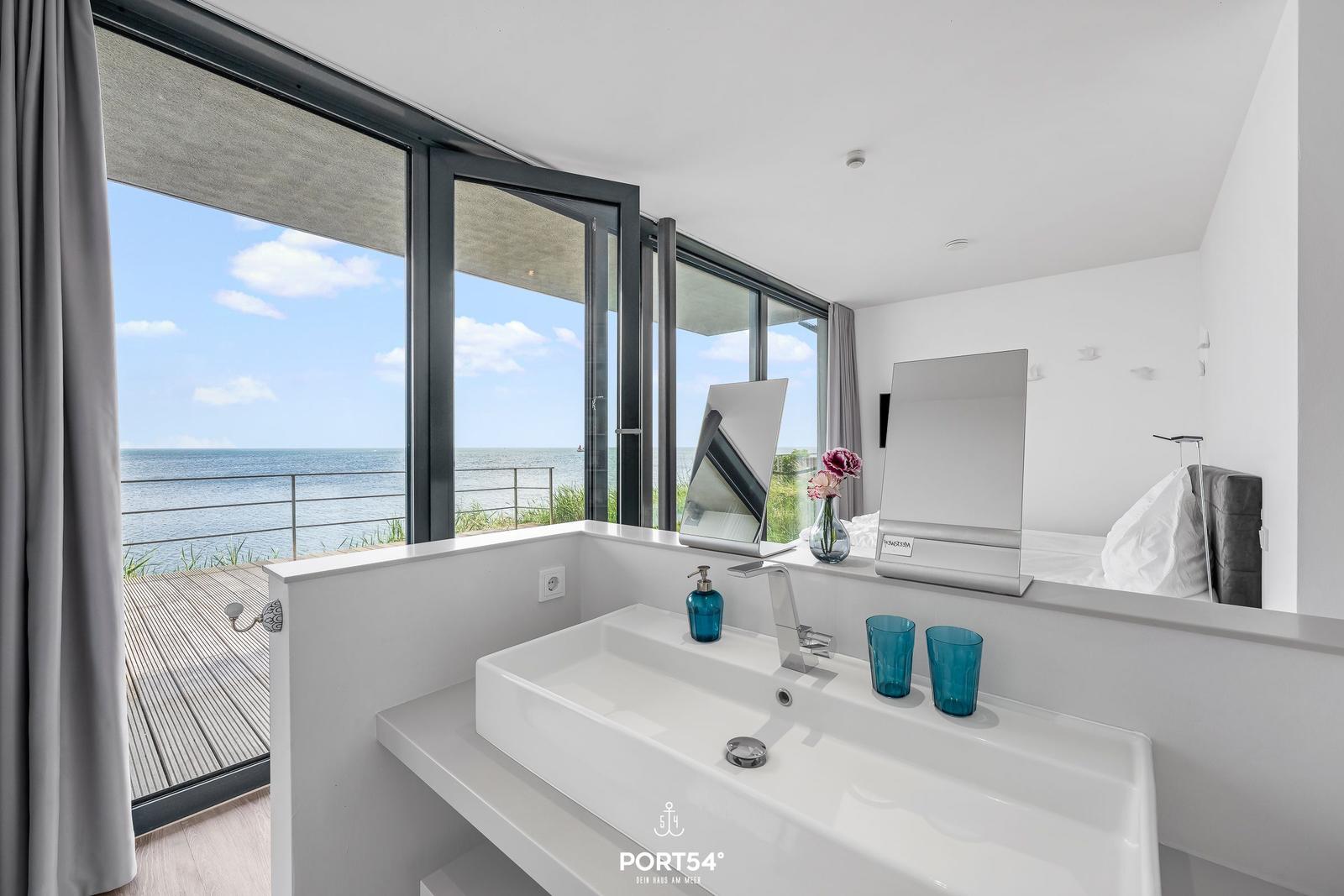 Badezimmer mit Blick aufs Meer und integriertem Waschbecken