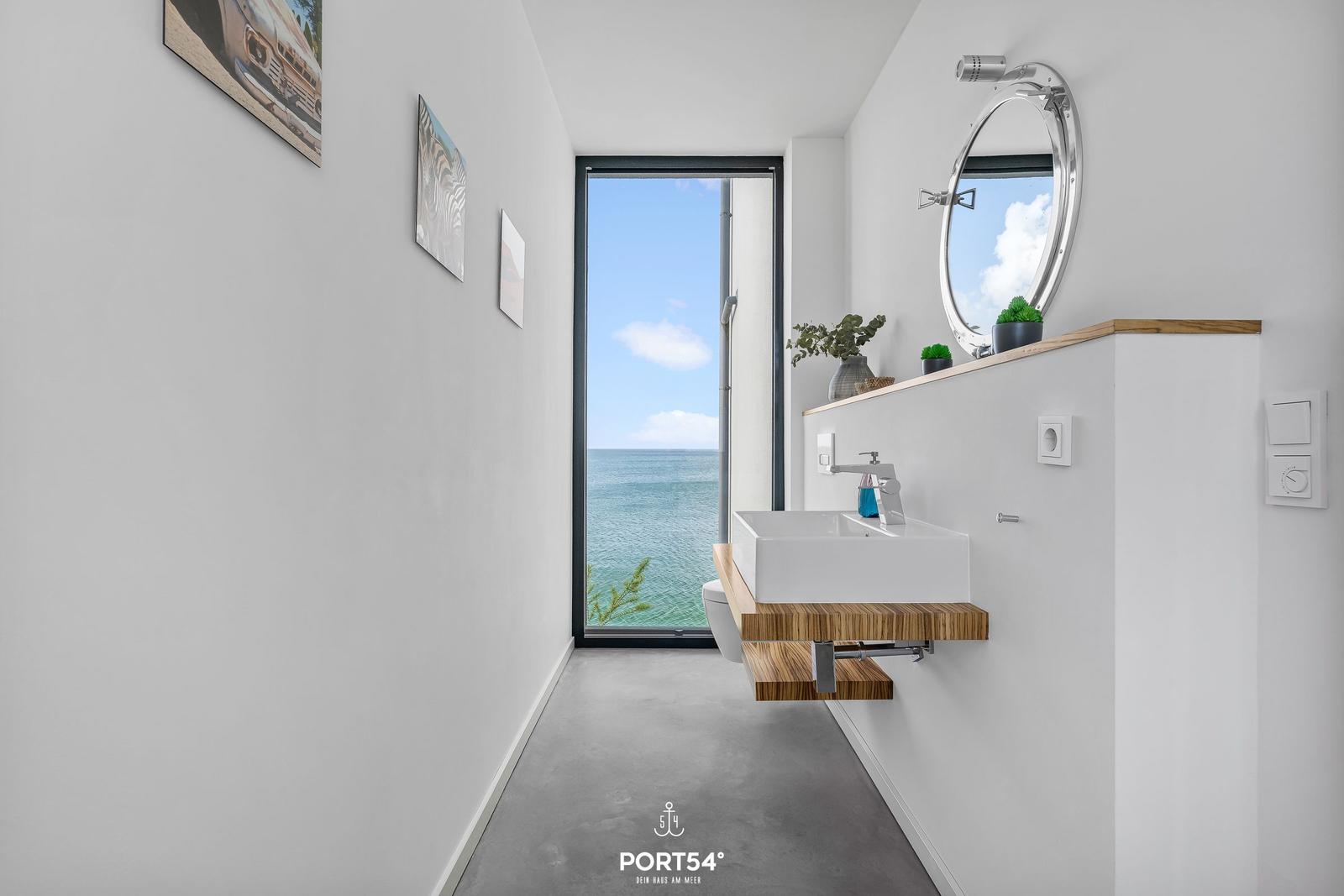 Badezimmer mit Blick aufs Meer, Spiegel und Waschbecken