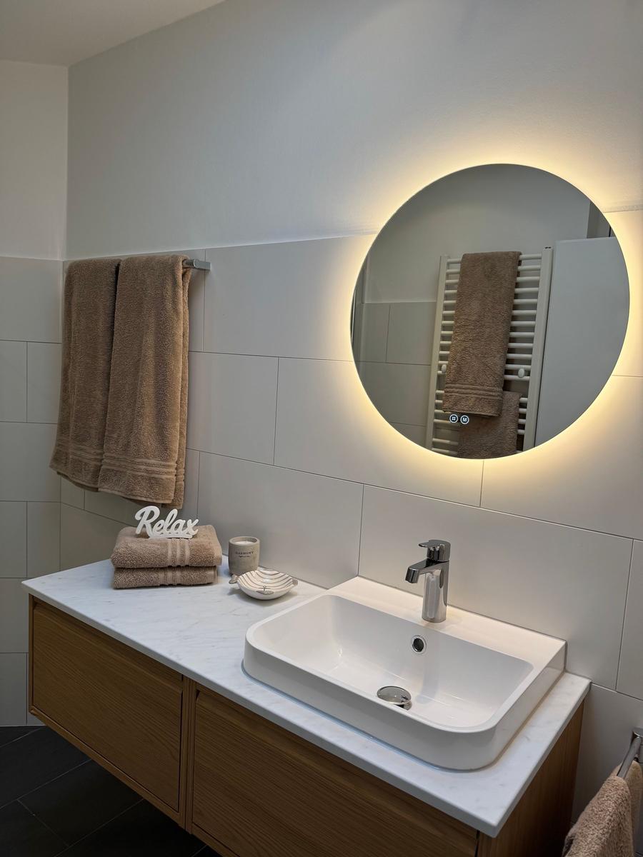 Badezimmer mit Waschtisch, Spiegel und Handtüchern