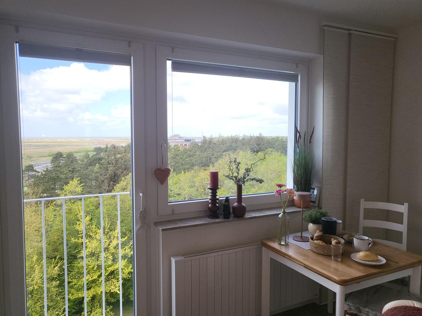 View of green landscape from balcony with table and chair