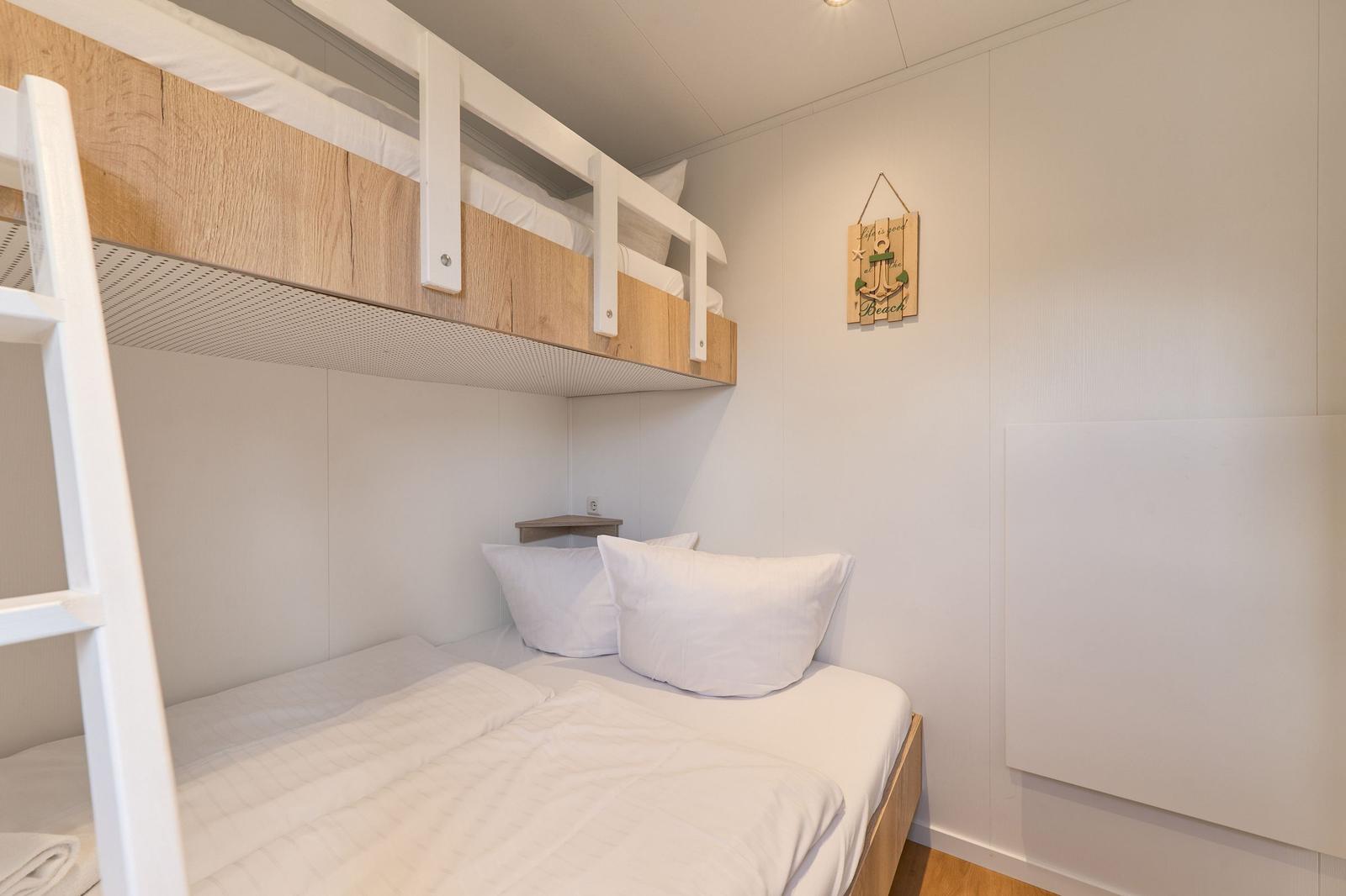 Zimmer mit Doppelbett und oberem Bett, Wanddekoration mit Anker.