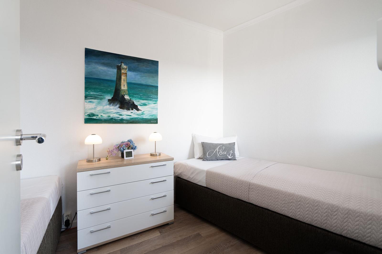 Zimmer mit zwei Betten, Schrank und Leuchten an der Wand mit Leuchten.