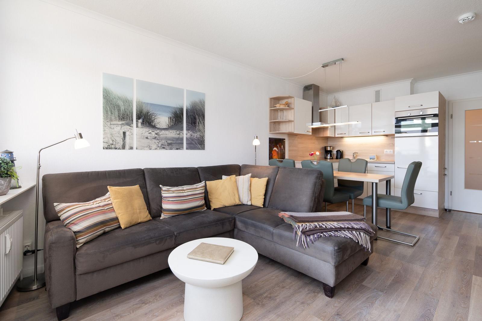 Wohnbereich mit Sofa, Esstisch und Küchenzeile.