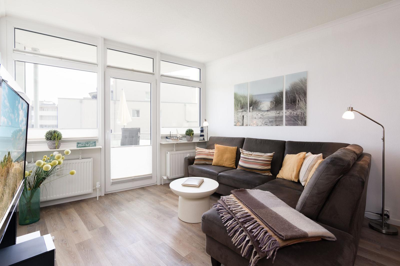 Wohnzimmer mit Sofa, Couchtisch und Fenster zur Terrasse.