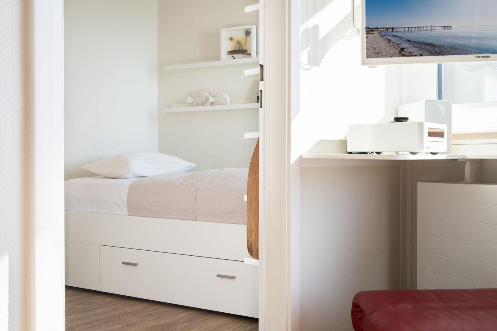 Bedroom with bed, closet, and TV on the wall.