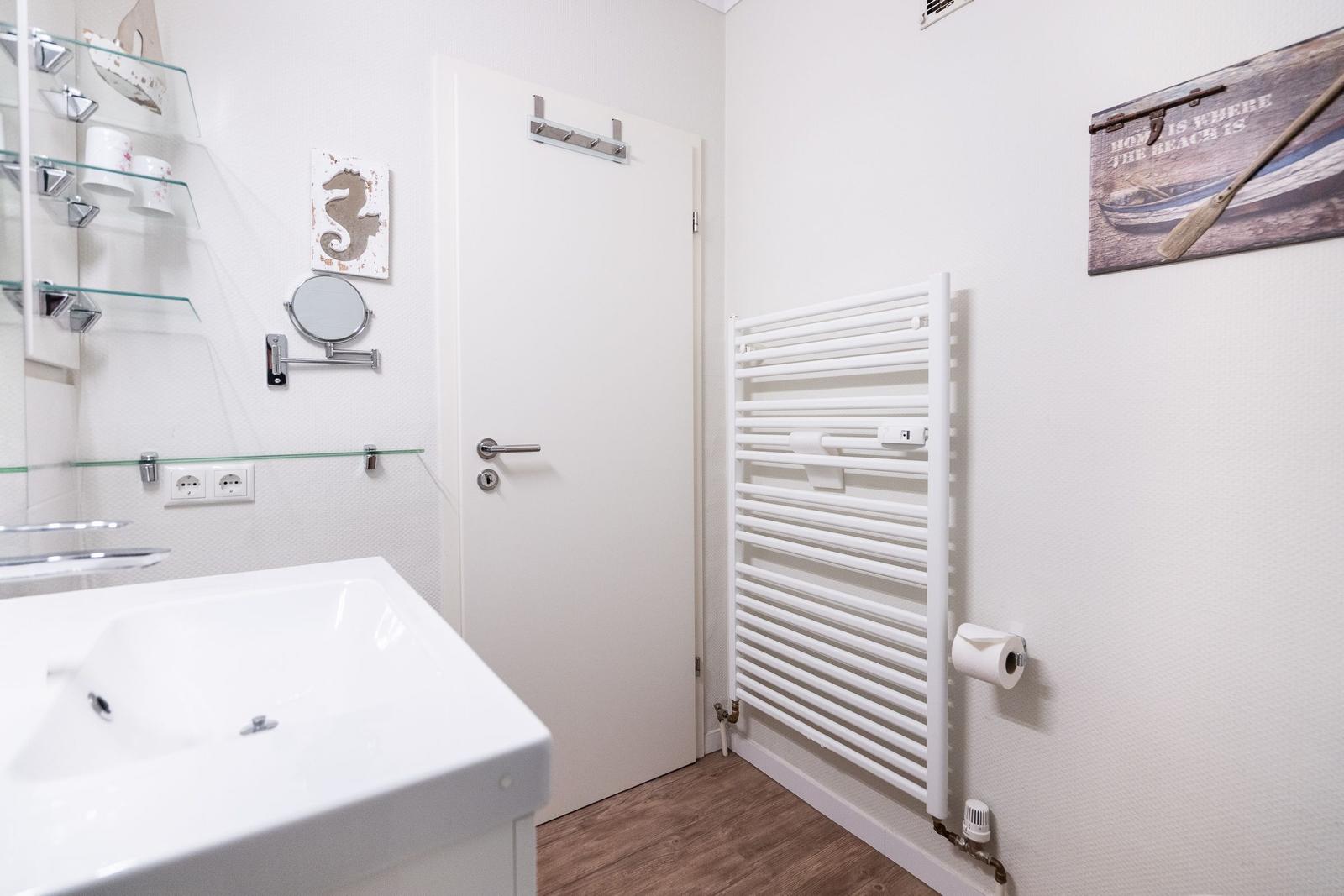 Bathroom with sink, heater, and wall decor