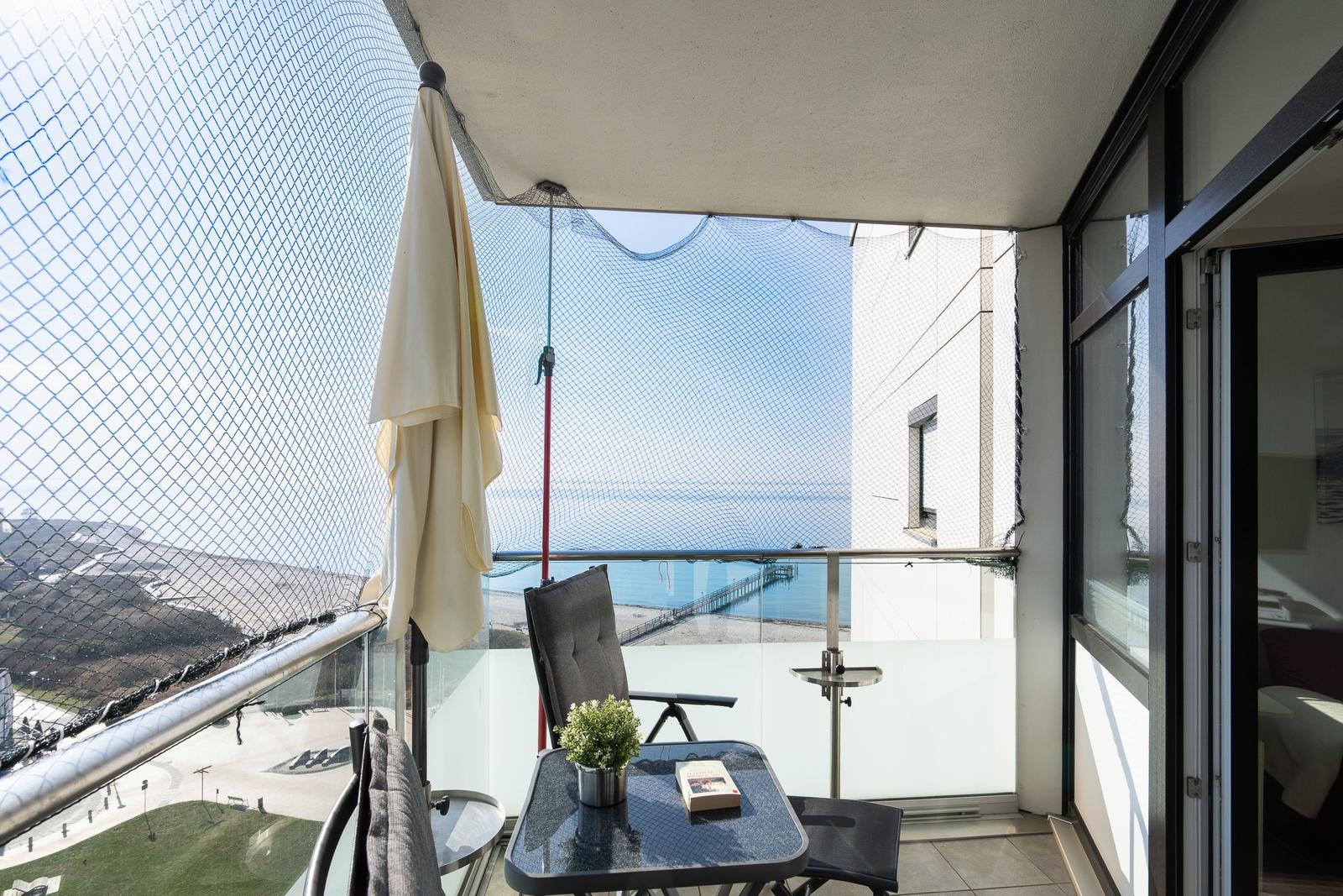 Balcony with seating and sea view.