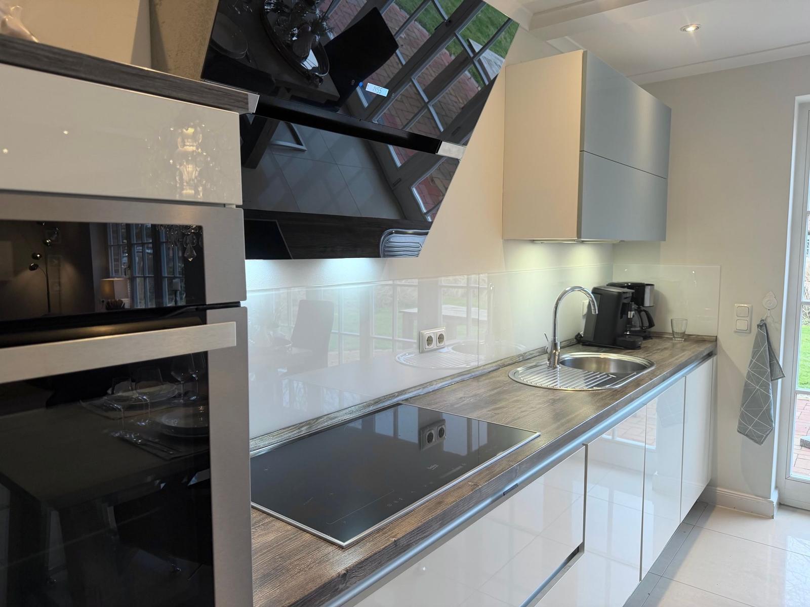 Moderne Küche mit Induktionskochfeld, Spüle und Hochschrank