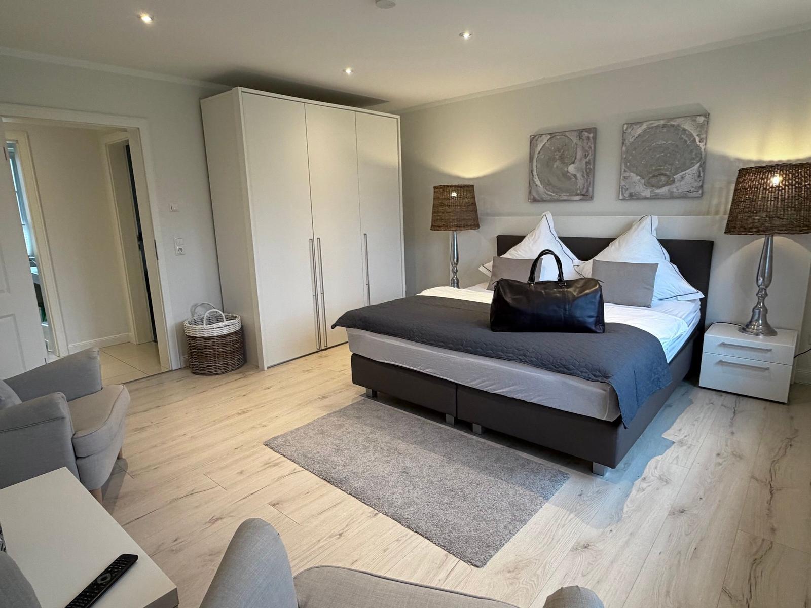 Schlafzimmer mit Bett, Kleiderschrank und Nachttisch