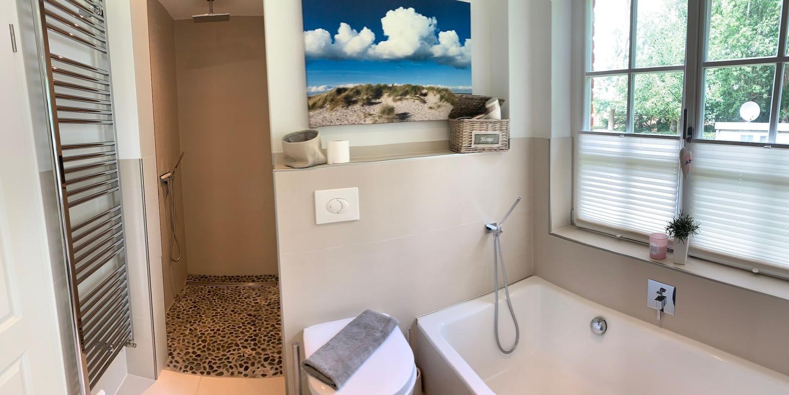 Badezimmer mit Dusche, Badewanne und Fenster