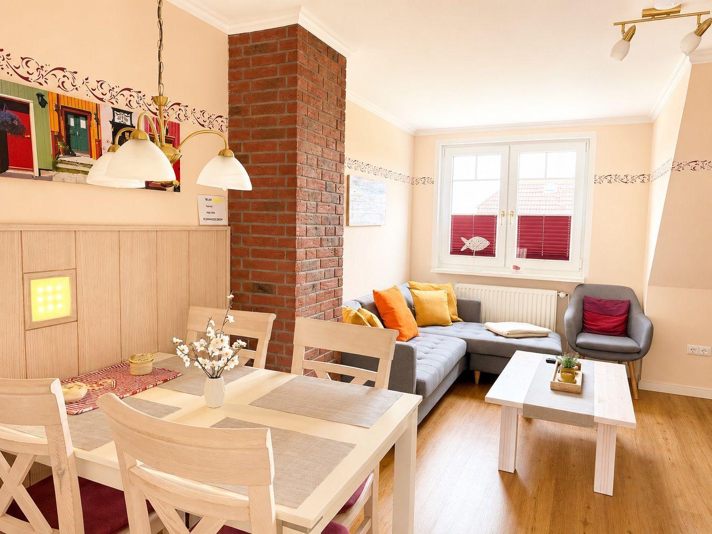 Wohn- und Essbereich mit Sofa, Esstisch und Backsteinwand.